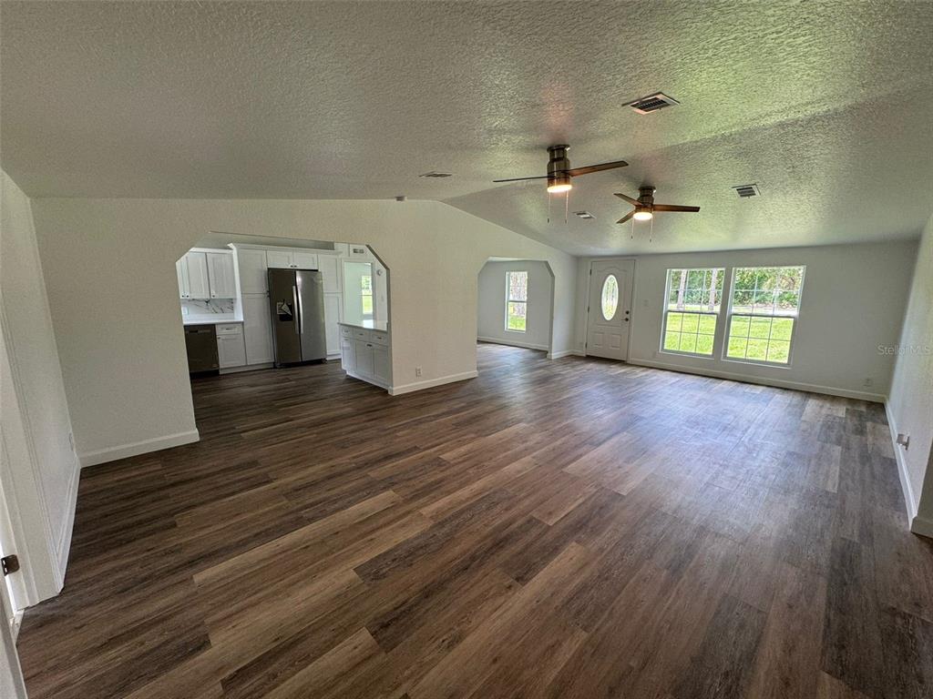 4970 Harrison Road Mims, FL 32754 - Photo 6 of 30 an empty room with wooden floor and windows