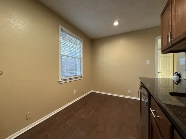 a room with a sink wooden floor and a window