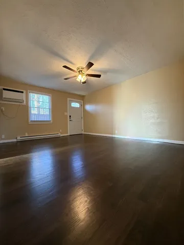 a view of a livingroom with wooden floor and a window