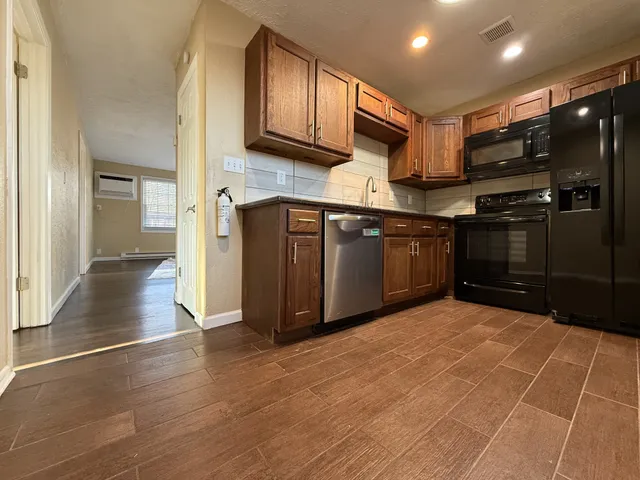 a kitchen with stainless steel appliances granite countertop a refrigerator and a stove