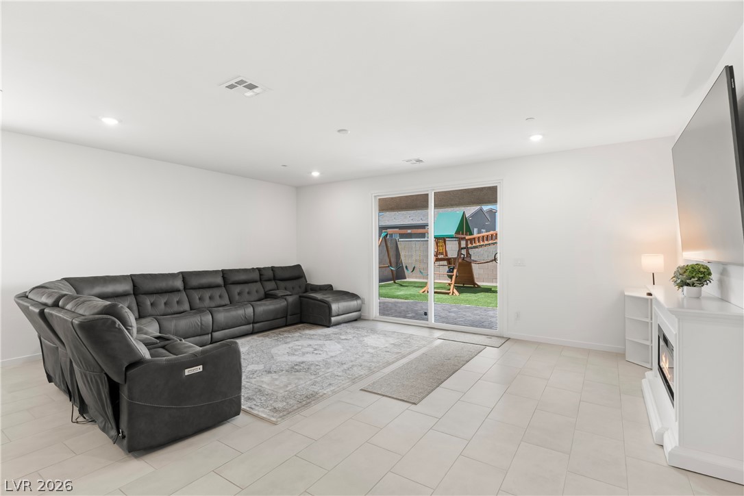 320 Isla Enclave Way Henderson, NV 89011 - Photo 11 of 49 Relax in this living area featuring a fireplace and convenient outdoor access.