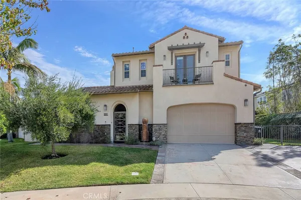 a front view of a house with a yard and potted plants