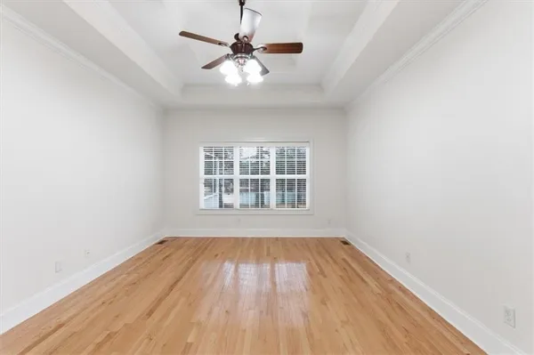 an empty room with a window and wooden floor