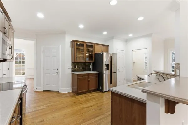 a kitchen with stainless steel appliances kitchen island granite countertop a refrigerator and a sink