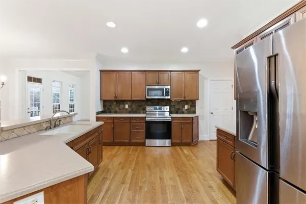a large kitchen with a center island and stainless steel appliances