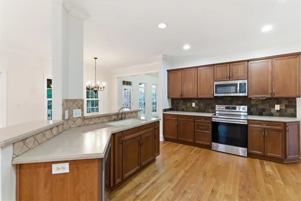 a large kitchen with granite countertop a sink and stove top oven