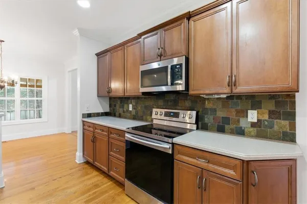 a kitchen with stainless steel appliances granite countertop a stove a sink and a microwave