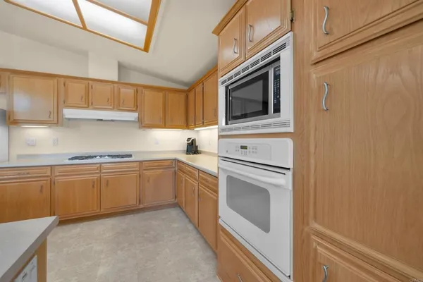 a kitchen with granite countertop white cabinets stainless steel appliances and sink