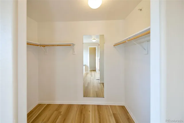 a view of walk in closet with wooden floor