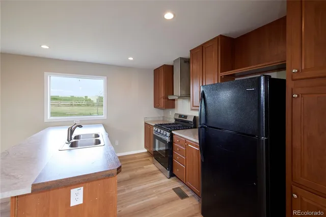 a kitchen with a refrigerator a stove top oven a sink and dishwasher