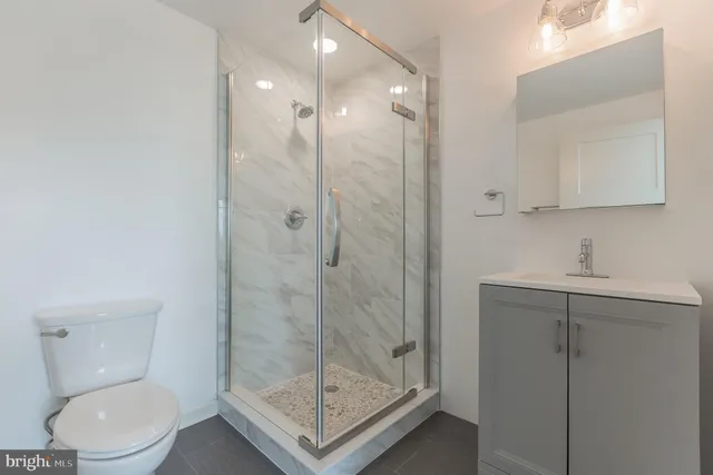 a bathroom with a shower a toilet and sink