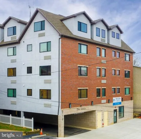 a front view of a building with glass windows and a ceiling fan