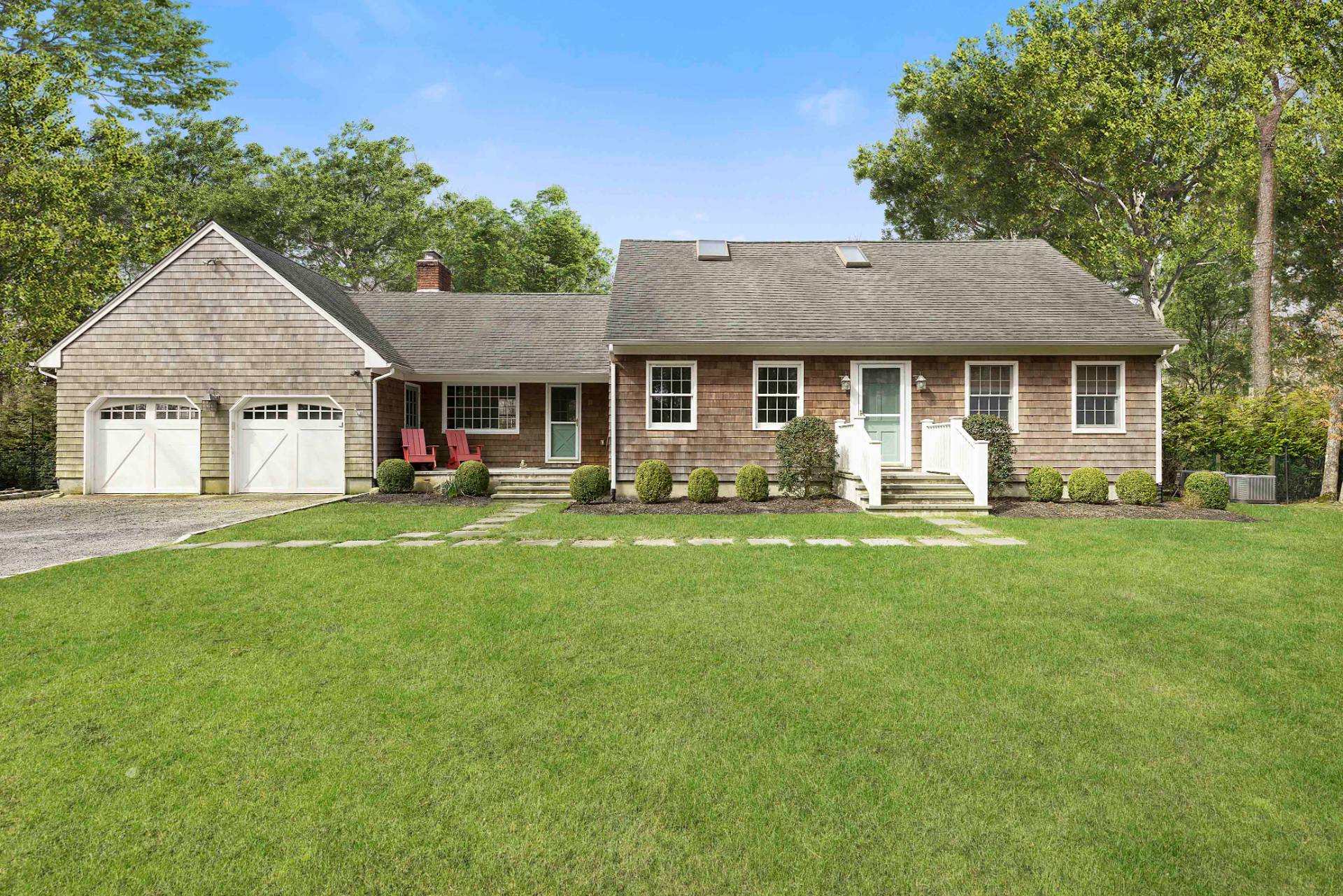 a front view of a house with a yard and trees