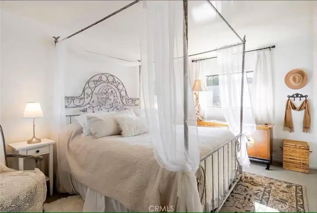 70138 Sullivan Road Twentynine Palms, CA 92277 - Photo 15 of 68 a bed room with a bed and a chandelier