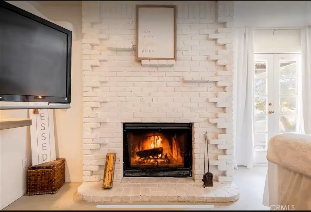 70138 Sullivan Road Twentynine Palms, CA 92277 - Photo 17 of 68 a living room with a fireplace a flat screen tv and a fireplace