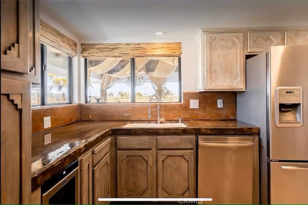 70138 Sullivan Road Twentynine Palms, CA 92277 - Photo 5 of 68 a kitchen with stainless steel appliances granite countertop a sink a stove a refrigerator a counter top space and cabinets