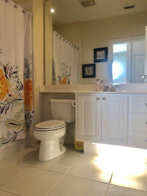 1836 Jeaga Drive Jupiter, FL 33458 - Photo 12 of 20 a bathroom with a toilet sink and mirror