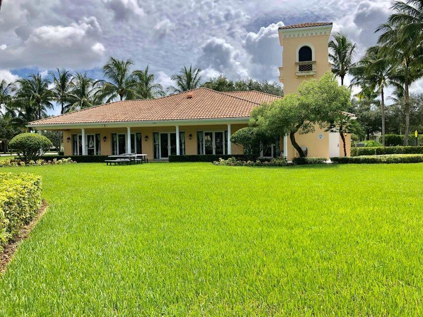 1836 Jeaga Drive Jupiter, FL 33458 - Photo 19 of 20 a view of a white house with a big yard and potted plants and large trees