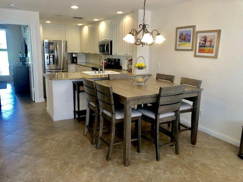 1836 Jeaga Drive Jupiter, FL 33458 - Photo 3 of 20 a kitchen with kitchen island a dining table and chairs