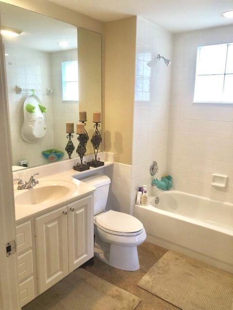 1836 Jeaga Drive Jupiter, FL 33458 - Photo 6 of 20 a bathroom with a granite countertop toilet sink and mirror