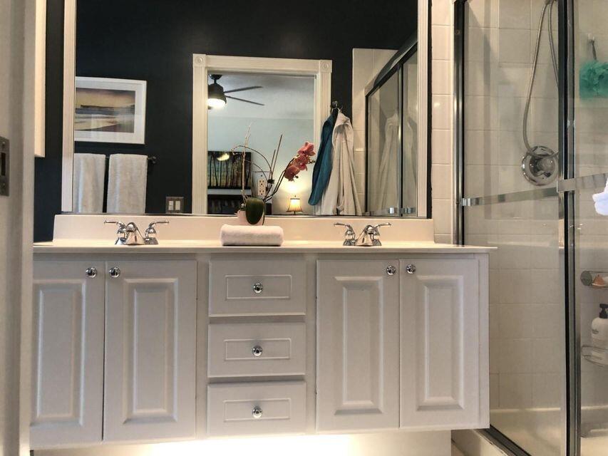 1836 Jeaga Drive Jupiter, FL 33458 - Photo 9 of 20 a bathroom with a double vanity sink and a mirror
