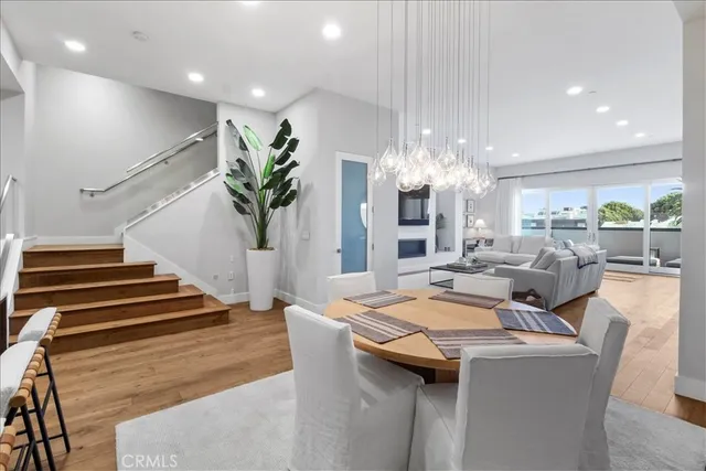 a living room with furniture a rug potted plant and a large window