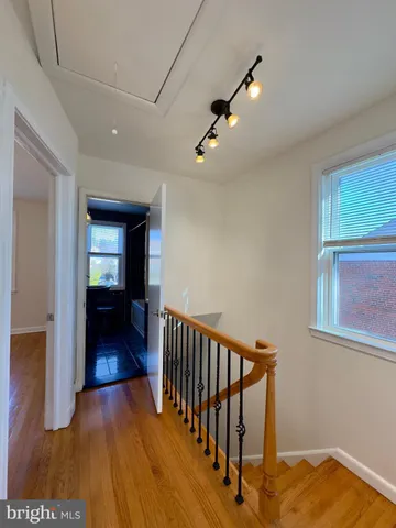a view of a hallway with wooden floor and stairs