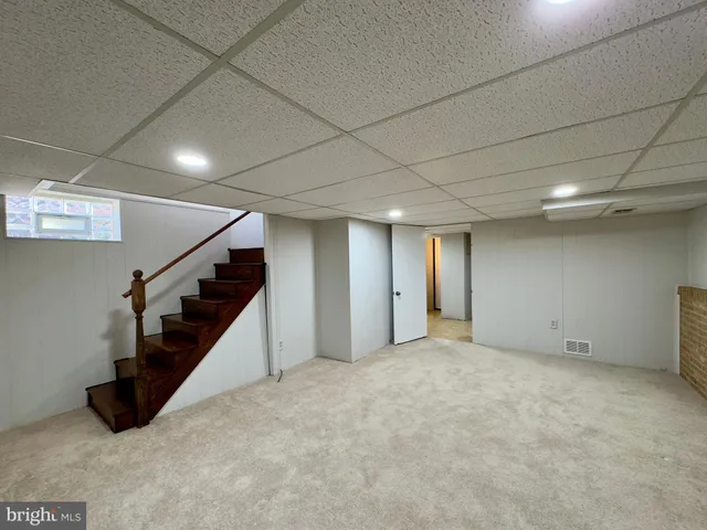 an empty room with wooden floor and stairs