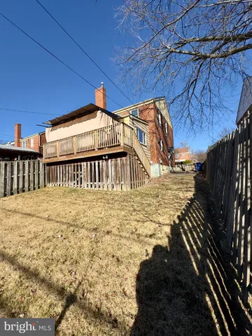 a view of a backyard with table and chairs with wooden fence