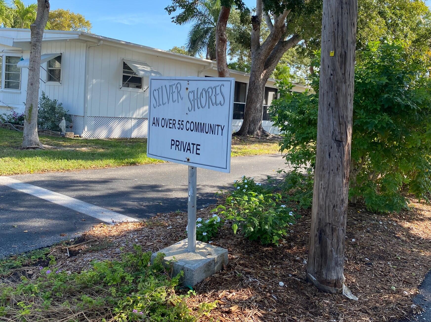 808 South Silver Circle Key Largo, FL 33037 - Photo 15 of 24 a sign that is sitting in front of a house with wooden fence