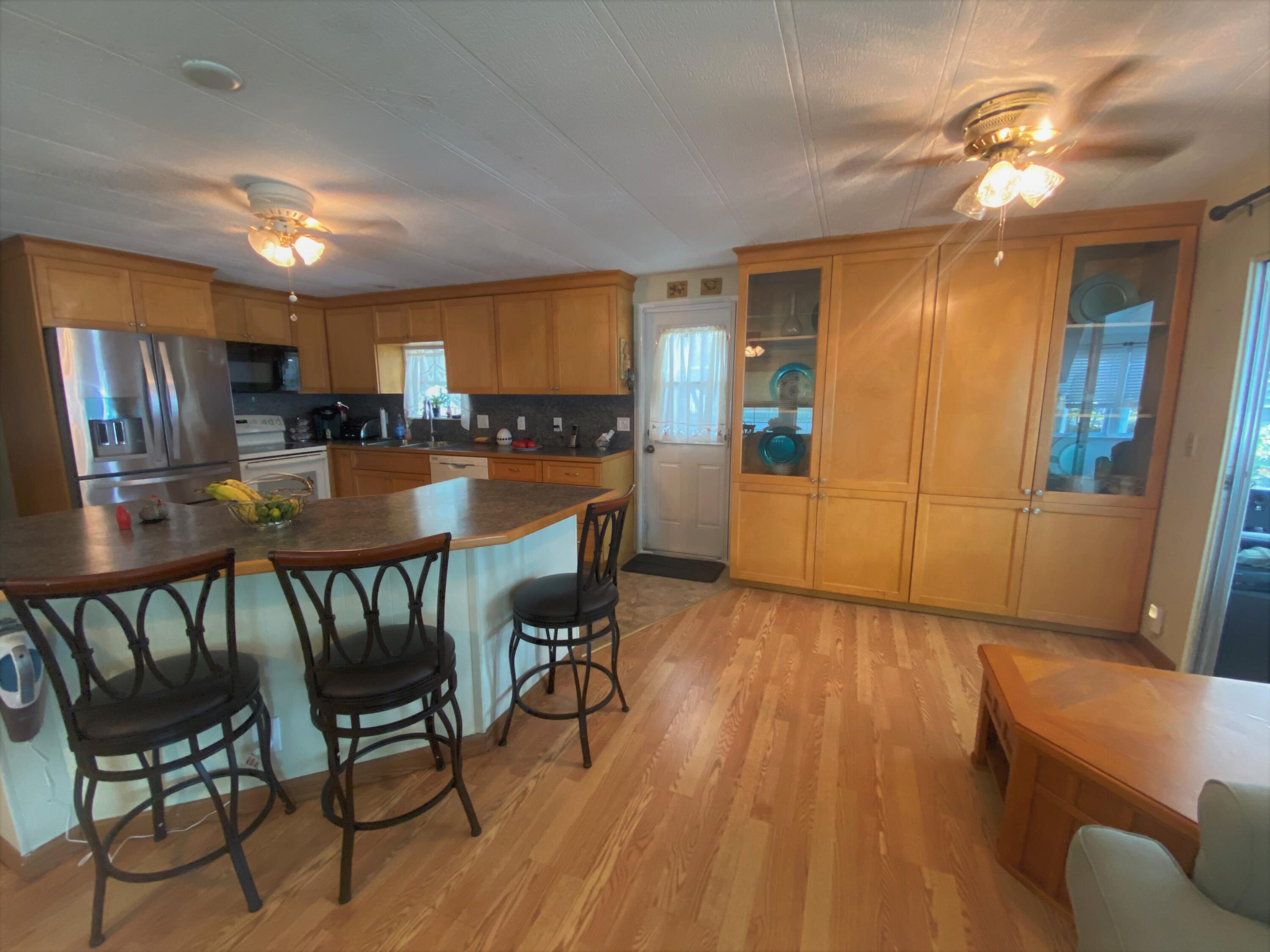 808 South Silver Circle Key Largo, FL 33037 - Photo 8 of 24 a kitchen with stainless steel appliances wooden floors dining table and chairs