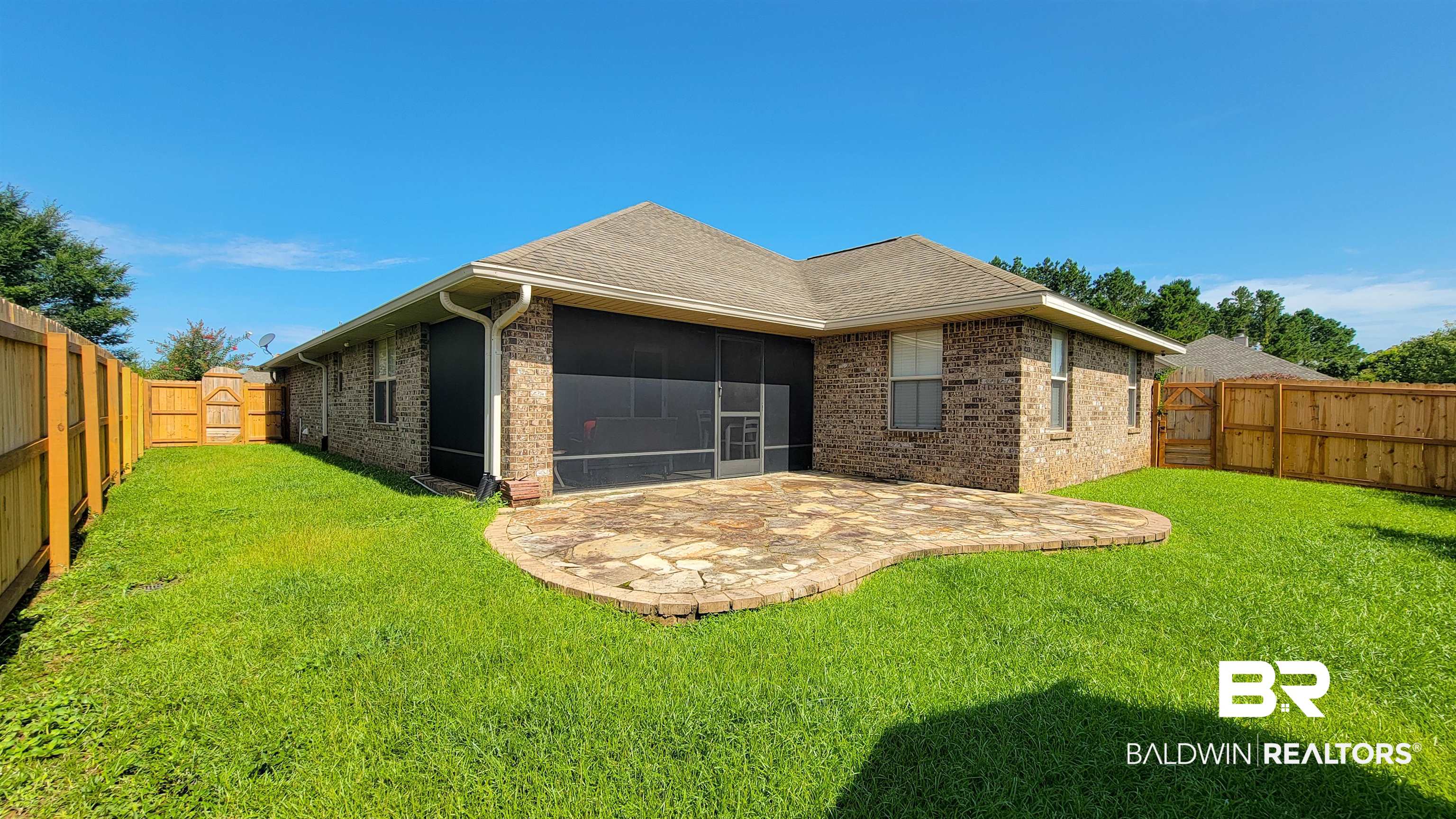 1704 Arcadia Drive Foley, AL 36535 - Photo 46 of 52 Rear view of property featuring a sunroom, brick siding, a fenced backyard, a patio, and roof with shingles