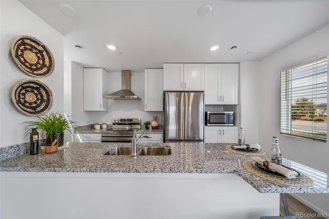 a kitchen with a refrigerator and a stove top oven