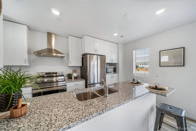 a kitchen with a refrigerator and a stove top oven