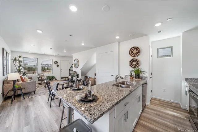 a very nice looking dining room with kitchen island stainless steel appliances a sink and living room view