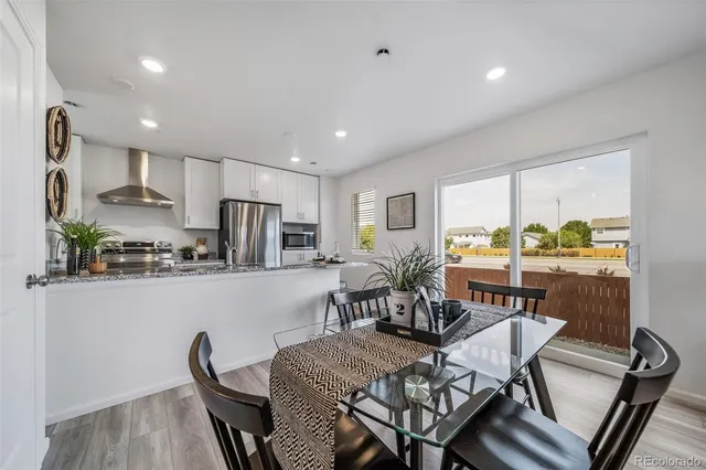 a view of a dining room with furniture a rug and wooden floor