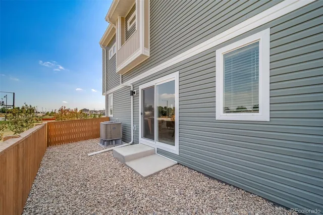 a view of backyard with large trees and wooden fence