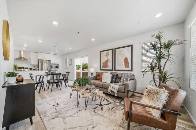 a living room with furniture potted plant and a large window