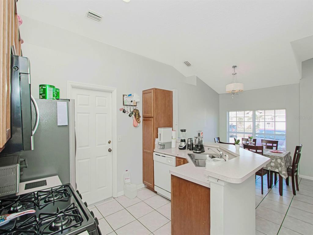 6936 Needle Point Drive Orlando, FL 32822 - Photo 11 of 29 a kitchen with a sink and refrigerator