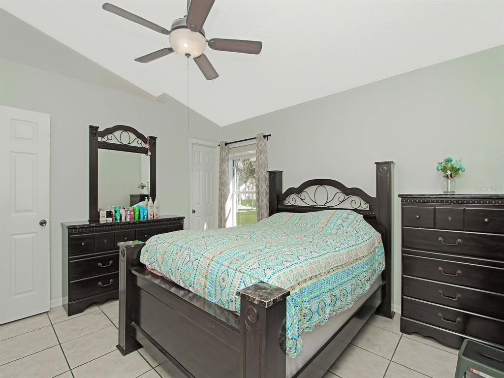 6936 Needle Point Drive Orlando, FL 32822 - Photo 13 of 29 a bedroom with a bed and a dresser