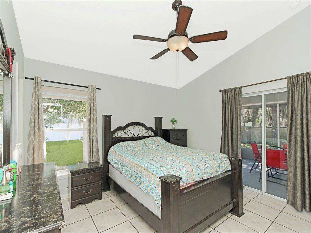 6936 Needle Point Drive Orlando, FL 32822 - Photo 14 of 29 a bedroom with a bed and a chandelier