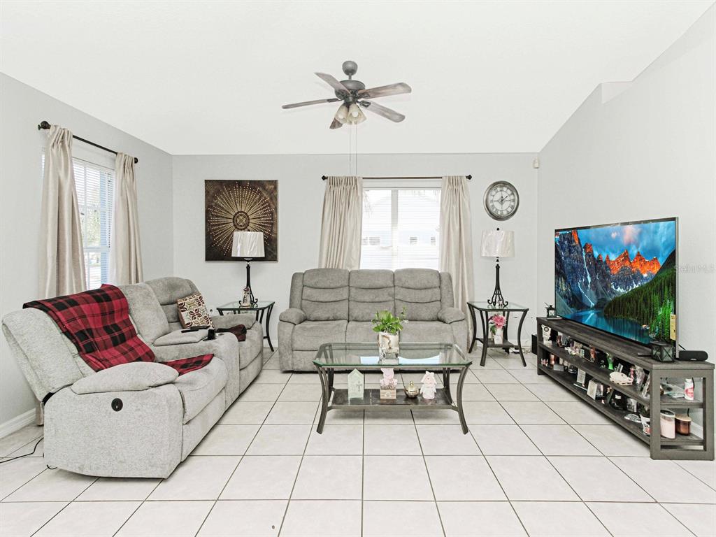 6936 Needle Point Drive Orlando, FL 32822 - Photo 5 of 29 a living room with furniture and a flat screen tv