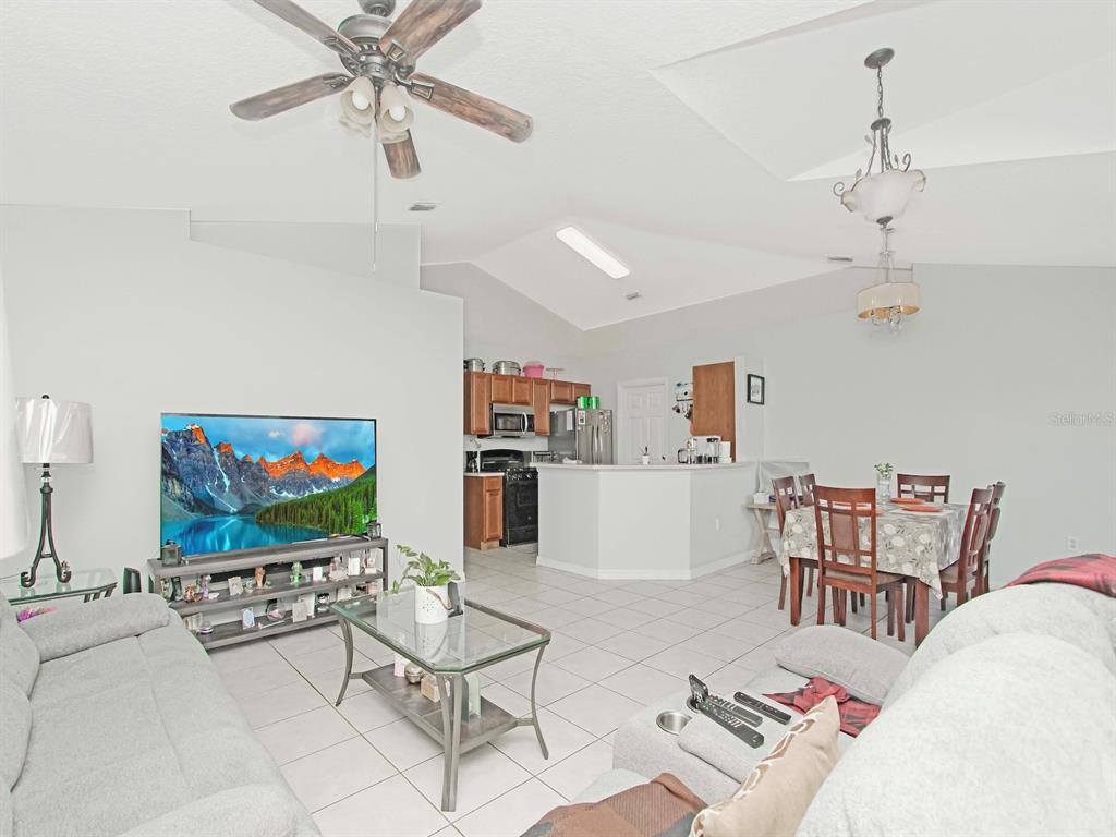 6936 Needle Point Drive Orlando, FL 32822 - Photo 7 of 29 a living room with furniture and a flat screen tv