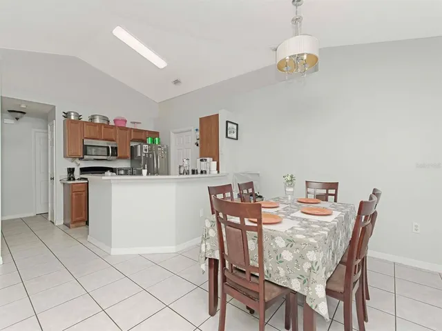 a dining room with furniture and kitchen view