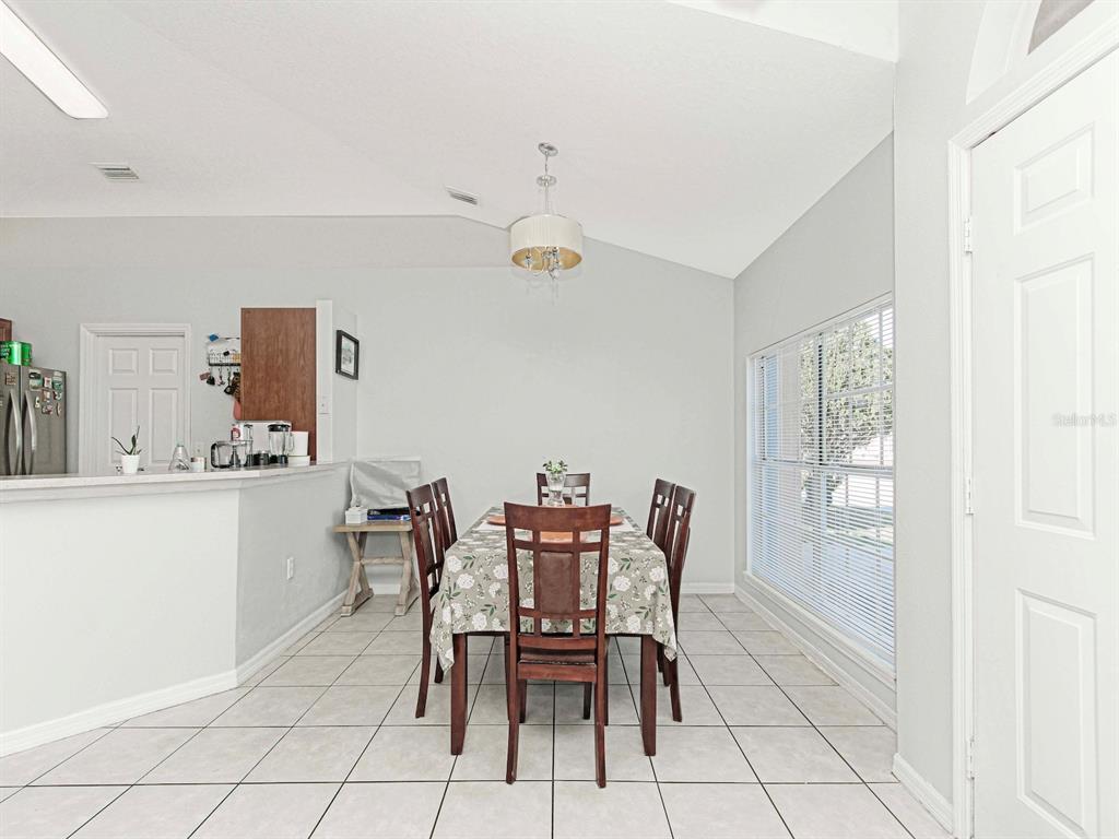 6936 Needle Point Drive Orlando, FL 32822 - Photo 9 of 29 a dining room with furniture and window