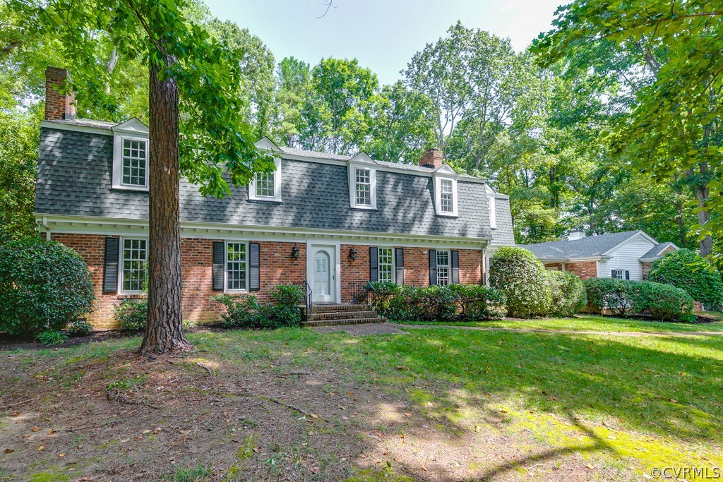 10300 Apache Road Richmond, VA 23235 - Photo 1 of 48 a view of a big yard in front of a brick house with plants and large trees