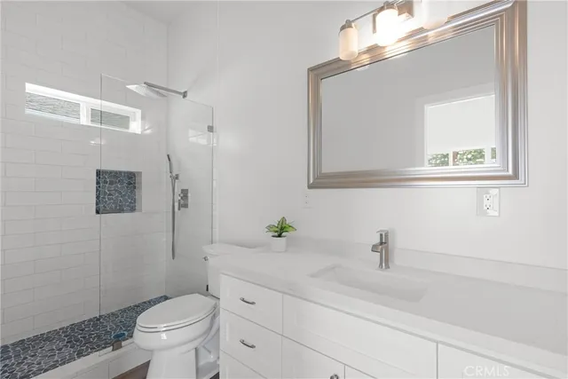 a bathroom with a sink a toilet and shower