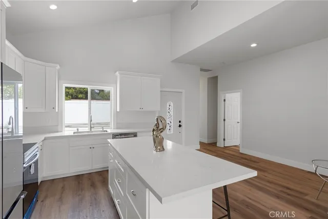 a kitchen with a sink cabinets and wooden floor