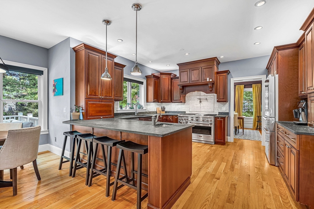 24 Summit Road Wellesley, MA 02482 - Photo 6 of 27 a kitchen with stainless steel appliances granite countertop a kitchen island hardwood floor sink stove dining table and chairs