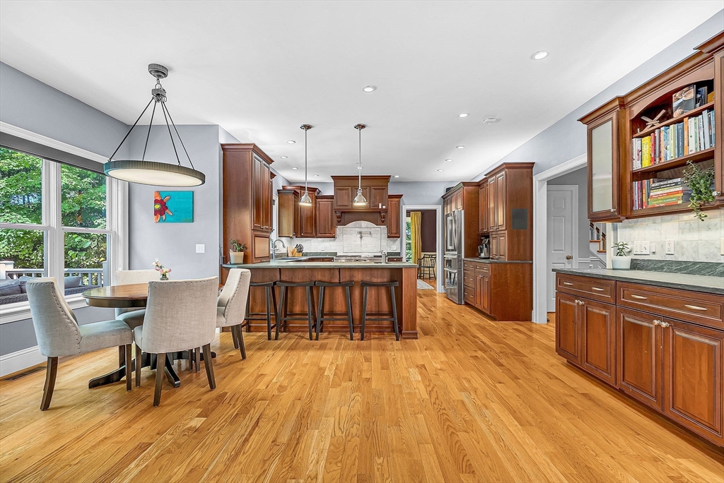24 Summit Road Wellesley, MA 02482 - Photo 7 of 27 a large kitchen with stainless steel appliances kitchen island granite countertop a large island a stove a refrigerator a sink a dining table and chairs with wooden floor